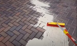 brampton-paving-employee-spreading-sand-with-a-broom