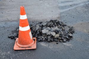 road-cone-with-pothole-on-pavement