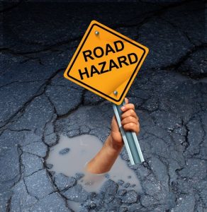 road-hazard-sign-on-road-with-pothole